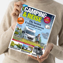 Hellebekleidete Person hält das Magazin „Camping & Reise“ mit blau-gelbem Titeltext und Unterzeile „Die besten Frühlingstouren in Deutschland und weltweit“. Auf dem Cover: ein weißes Wohnmobil auf einer Wiese, daneben eine stehende Person, kleinere Bilder mit Campingplätzen und Wohnmobilen, Aufschriften u. a. „Glamping in Kärnten“, „Süddeutschland“, „Campingtipp Lahn“, orangefarbener Kreis „30 Reiseziele zum Saisonstart“.