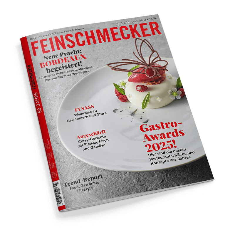Titelbild der Zeitschrift „Feinschmecker“ mit roter Schrift auf grauem Hintergrund; mittig ein dekoriertes Dessert mit Himbeeren, Blattdekor und Schoko-Ornament auf weißem Teller, daneben Texte wie „Gastro-Awards 2025!“, „Elsass – Weinreise zu Newcomern und Stars“ und „Angeschärft – Curry-Gerichte mit Fleisch, Fisch und Gemüse“, am linken Rand roter Buchrücken mit weißer Aufschrift „50 Jahre Feinschmecker“.