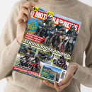 Person in beigefarbenem Strickpullover hält eine Ausgabe des Magazins „MOTORRAD NEWS“ mit Titelthema „Stimmungskanonen“. Auf dem Cover mehrere Motorradfahrende in Schutzkleidung und Helmen auf unterschiedlichen Modellen, u. a. Kawasaki Z650, Suzuki GSX-8S, Yamaha MT-07. Weitere Textfelder: „Tests Reifen & Klapphelme“, „Abteilung Attacke“, „Bollerbärchen“, „Lofoten & Niederlande“. Farbiges Layout mit roten, gelben und blauen Akzenten.