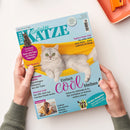 Titelbild des Magazins „Geliebte Katze“, Ausgabe Juli 2026, mit einer grauen Katze in einer gelben Hängematte vor hellblauem Hintergrund. Hauptüberschrift: „Einfach cool bleiben!“, dazu Themen wie „Tapfere Katze Lini“, „Forschung im Fokus“, „Vitamine aus der Tube“ und „Lieben wir unsere Katzen zu sehr?“. In menschlichen Händen gehalten, sichtbarer Barcode oben rechts.