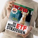 Person in beigefarbenem Strickpullover hält die Zeitschrift „Focus Money“ mit Titelbild eines hellen Stierfigurenkopfs auf einem Schachsockel vor unscharfem blaugrünem Hintergrund. Hauptüberschriften: „Die besten ETF Strategien“, „Bis 30 % Chance pro Jahr“, „So passen Sie Ihr Depot der neuen Realität an“. Oben Themenzeile zu China, Iran und Tourismus.