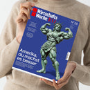 Eine Person in beigefarbenem Pullover hält ein Magazin mit blauem Cover, Titel „WirtschaftsWoche 100“, Ausgabe „N°28“. Auf dem Titelmotiv eine muskulös dargestellte Freiheitsstatue mit grünlicher Patina in Bodybuilder-Pose. Textausschnitte: „Amerika, du machst es besser“, „Volkswagen“, „Schwellenländer“, „Ruhestand“. Weitere Information unten zu Wirtschaftsthemen, Datum 3. Juli 2026.