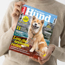 Person in beigem Wollpullover hält eine Ausgabe des Magazins „Partner Hund“, Titel Juni 2025. Auf dem Cover sitzt ein hellbraun-weißer Hund mit Leine auf einem Holzsteg vor Wasser und Bergen. Textaufschriften: „Lass die anderen reden“, „11 Tipps für spannende Spaziergänge“, „T olles Training“, „Gesundheit – Worauf üble Gerüche hindeuten“, „Reise‑Reportage: Lago Maggiore“ und „Rasse‑Porträts Eurasier & Stabijhoun“.