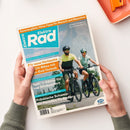 Titelblatt der Zeitschrift „ElektroRad“, gehalten von zwei Händen über hellem Hintergrund. Abgebildet ist ein männlich und ein weiblich gelesener Mensch mit Helm auf E-Bikes vor Gebirgslandschaft. Sichtbare Texte: „Für neue Horizonte – SUV-Bikes mit High-End-Technik“, „Test: 11 Sättel für top Sitzkomfort“, „Fränkische Schweiz: Ein Paradies für Radler“, „Sommerglück: Hitze-Tipps für Mensch und Maschine“, Logo „BVA BikeMedia“.