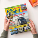 Titelblatt der Zeitschrift „promobil“ mit gelbem und blauem Logo, Ausgabe Juni 2025. Im Mittelpunkt ein silberfarbenes Wohnmobil „Adria Coral MB“ auf Straße, darunter Texte zu Testberichten und Reisethemen. Weitere sichtbare Schlagzeilen: „Transit mit Allrad“, „Camping am Wasser“ und „Eriba Touring 7 Base“. Gehalten von zwei Händen vor hellem Hintergrund, oben rechts orangefarbene Schale mit Stift.