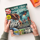 Magazintitel „welt der wunder“ mit rotem Logo oben links; zentrale Abbildung zeigt eine Hand, die eine Schachfigur mit US-Flagge auf einem Spielfeld über einer Weltkarte bewegt, umgeben von weiteren Figuren in Blau und Rot. Hauptüberschrift: „Wer herrscht die Welt? Im Jahr 2030“. Weitere sichtbare Texte: „Der neue Krieg der 4 Supermächte“, „Wie lebe ich länger?“, „Deutschlands geheime Wildnis?“ und „Das Walhalla-Rätsel“. Hände halten das Magazin über hellem Tisch.