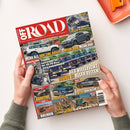 Magazintitel „OFF ROAD – Das 4x4-Magazin für die Freiheit auf Rädern“ in rotem Kopfbereich, darunter mehrere Fahrzeugfotos: Geländewagen, Pick-ups und Offroad-Fahrzeuge in verschiedenen Farben auf Schotter und Gelände. Schlagzeilen u. a.: „Mehr als nur eine Basis“, „Der vielleicht beste J aller Zeiten“, „Toyota Land Cruiser 6 Zyl. mit 8-Gang-Automatik“, „Additive“, „Bolivien“, „Ultra4 King of Germany 2026“. Gehalten von zwei Händen über hellem Tisch.