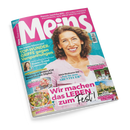 Titelblatt der Zeitschrift „Meins“ mit einer lächelnden weiblichen Person mittleren Alters vor türkisfarbenem Hintergrund. Hauptüberschriften: „Wir machen das Leben zum Fest!“, „TOP-WUNDER-GRIFFE gegen Verspannungen“, „Zeit für neue Abenteuer“. Weitere Texte zu Beauty-Trend Contouring, Sommergerichten, Reisen und Dekoration. Mehrere kleine Fotos von Speisen und Landschaften ergänzen das Layout.