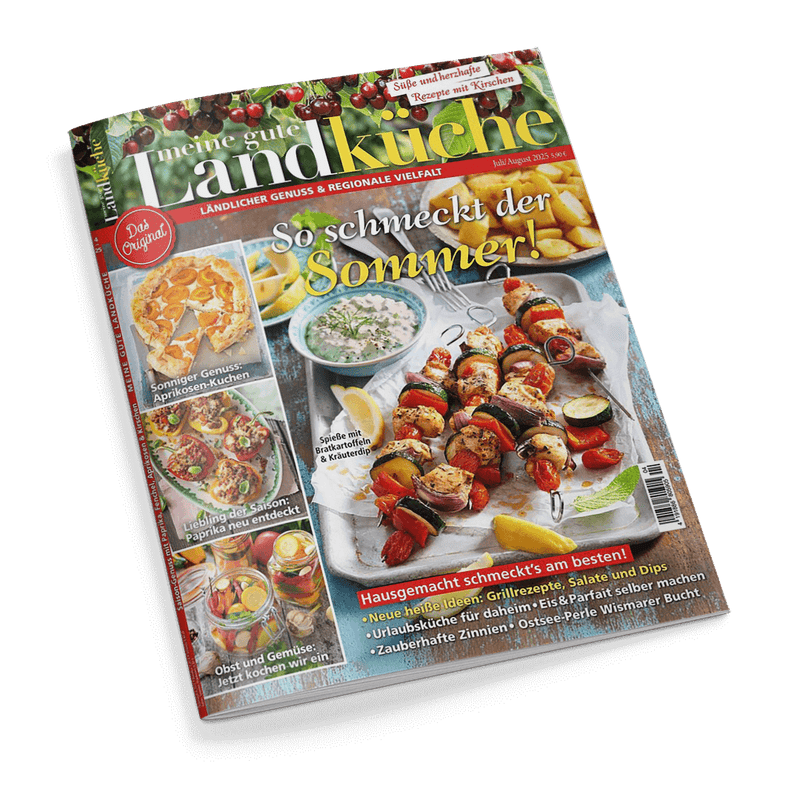 Titelbild der Zeitschrift „meine gute Landküche“ Ausgabe Juli/August 2025 mit dem Haupttitel „So schmeckt der Sommer!“, zentral ein Teller mit gegrillten Gemüsespießen, Bratkartoffeln, Zitronenscheiben und einem Kräuterdip; seitlich kleinere Abbildungen: Aprikosenkuchen, Paprika-Rezepte, Obst- und Gemüsegetränke; weitere Textelemente: „Hausgemacht schmeckt’s am besten“, „Süße und herzhafte Rezepte mit Kirschen“ und „Das Original“.