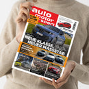 Helle, langärmlig bekleidete Person hält das Hochglanzmagazin „auto motor und sport“ in beiden Händen, Titelblatt mit rotem Logo oben links, zentral abgebildetem blauem BMW und Überschriften wie „NEUE KLASSE, NEUER MASSSTAB“. Weitere sichtbare Teaser zu Tests von Audi A3, Mercedes A-Klasse, Skoda Karoq und Alfa Romeo Giulia sowie Fotoaufnahmen mehrerer Autos und Landschaftsdarstellung unten auf dem Cover.