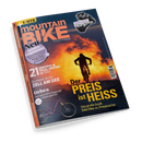 Titelblatt der Zeitschrift „MountainBIKE“ mit orange-gelbem Hintergrund, darauf eine Person auf einem Mountainbike vor einer Feuer- oder Wolkenkulisse. Textelemente u. a.: „Der Preis ist heiß“, „21 Enduro- & Trail-Reifen im Test“, „Orbea – Das neue E-MTB-Flaggschiff exklusiv getestet“, „Zell am See“. Oben rechts ein schwarzer Fahrradschaltmechanismus mit Schriftzug „Shimano XT Di2 im Stresstest“.