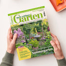 Zwei Hände halten die Zeitschrift „mein schöner Garten“, Ausgabe Juni 2025, mit grünem Titelkopf und Gartenszene auf dem Cover: ein blühender Sommergarten mit dichtem Pflanzenwuchs, Gartentisch, Stühlen und Blüten in Rosa, Gelb und Violett. Sichtbare Texte: „Richtig düngen leicht gemacht“, „Unsere 50 schönsten Ideen für Ihren Sommergarten“, „12 Seiten Gartenpraxis im Juni“, „Duftende Stauden entdecken“, Preisangabe und Webadresse.