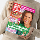Eine Person in beigefarbenem Pullover hält die Frauenzeitschrift „Bild der Frau“ mit roter Titelleiste. Das Cover zeigt eine lächelnde Frau mit braunen Haaren vor grünem Hintergrund, daneben Texte wie „Sensationelle Schlank-Limo“, „Puddingskuchen wie vom Bäcker“, „Meine Rückenschmerzen sind weg!“ und kleinere Themenfelder zu Ernährung, Gesundheit und Prominenten.