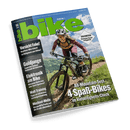 Titelbild der Zeitschrift „bike“ Ausgabe 06/2025 mit großem grün-blauem Logo, im Vordergrund eine sportlich gekleidete weibliche Person auf einem Mountainbike auf einem schmalen Naturpfad vor alpiner Bergkulisse unter blauem Himmel; Schlagzeilen: „Vorsicht Fake!“, „Goldjunge“, „Elektronik am Bike“, „Watt-Training“, „Wechsel-Welle“, „All-Mountain-Test: 4 Spaß-Bikes im Vielseitigkeits-Check“, „Dolomiten – die besten Touren im Eggental“.