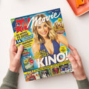 Titelbild der Zeitschrift „TV Movie“ mit einer lächelnden weiblichen Person mit schulterlangem blondem Haar in blauem Oberteil vor hellem Hintergrund. Sichtbare Texte: „Der perfekte TV-Guide“, „14 Tage Premium-Programm“, „Ganz großes Kino!“, „Die Highlights aus Mediatheken & Streaming“, „Mission: Impossible“, „Superhelden der Wüste“. Unten Filmfotos von „House of Gucci“, „Shazam“, „Bridgerton“ und weiteren Produktionen.