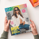 Titelblatt der Zeitschrift „Cosmopolitan“ (Ausgabe Juni 2025) mit einer weiblichen Person in offenem weißen Hemd, Jeans und Sonnenbrille vor grauem Hintergrund; sichtbare Überschriften: „LET LOVE RULE“, „MUT IST MEIN MUSKEL“, „BULLSHIT? BINGO“, „KOMM NÄHER“ sowie rosafarbener Kreis mit Text „COVERSTAR MILEY CYRUS“, Schriftzug „COSMOPOLITAN“ in regenbogenfarbenem Verlauf, gehalten von zwei Händen über hellem Tisch mit orangefarbener Ablage.