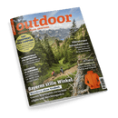 Titelbild der Zeitschrift „outdoor – Wandern. Reisen. Abenteuer.“ mit großem orangefarbenem Schriftzug vor Alpenpanorama; im Vordergrund drei wandernde Personen auf schmalem Gebirgspfad durch grüne Berglandschaft. Sichtbare Textelemente: „Bayerns stille Winkel“, „Abenteuer Jotunheimen“, „TOP-EQUIPMENT FÜRS CAMPING“, „IM CHECK: SOFTSHELLS“, daneben ein orangefarbener Softshell-Mantel und ein Barcode am rechten unteren Rand.