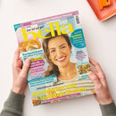 Titelblatt der Frauenzeitschrift „bella“, Ausgabe vom 3. Juli 2026, mit einer lächelnden weiblichen Person im gestreiften Oberteil vor hellgelbem Hintergrund. Überschriften u. a.: „Abnehmen mit leichten Stullen“, „Kuchenträume mit süßen Früchten“, „Wohlfühl-Sommer – Heilkraft des Schwimmens“, „Fit werden in 2 Minuten“ und „Mehr Glanz und Volumen fürs Haar“. Hände halten das Magazin über einem weißen Tisch mit orangefarbenem Tablett.
