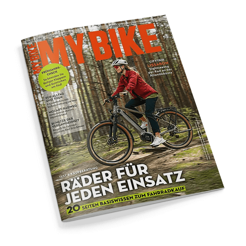 Titelbild der Zeitschrift „MY BIKE“, Ausgabe 3/2025, zeigt eine weiblich gelesene Person mit weißem Helm, roter Jacke und dunkler Hose auf einem grauen E-Bike im Nadelwald; sichtbar sind die Schlagzeilen „Räder für jeden Einsatz“, „20 Seiten Basiswissen zum Fahrradkauf“ sowie Themen u. a. zu Citytrip Lissabon, Frühjahrs-Check, Mozart-Radweg und Tipps für Alltag und Tour.
