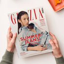 Titelblatt der Zeitschrift „Grazia“ mit einer jungen weiblichen Person in hellblauer Jeansjacke und Hose, leicht nach hinten gelehnt, vor beigem Hintergrund. Große rote Überschrift „SUMMER-JEANS – Die coolsten Trends der Saison“. Weitere sichtbare Texte: „WEDDING SPECIAL“, „Das Beste für Braut & Gäste“, „EXKLUSIV – Star-Designerin Diane von Fürstenberg über ihre Life-Lessons“. Zeitschrift wird von zwei Händen über weißem Untergrund gehalten.