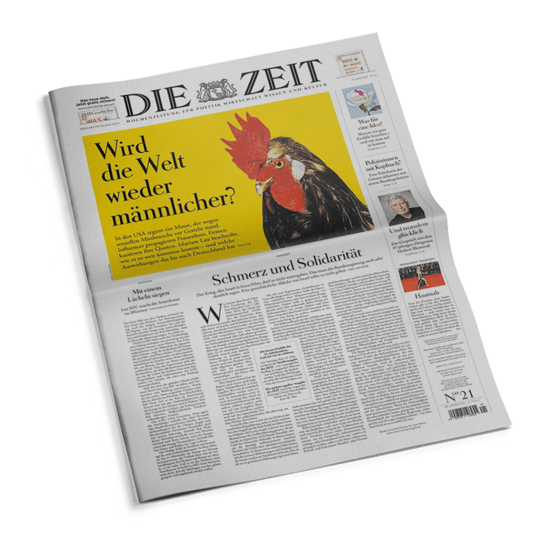 Zusammengefaltete Ausgabe der Wochenzeitung „DIE ZEIT“ mit großem gelbem Titelbild, zentral darauf ein Hahn mit rotem Kamm neben der Schlagzeile „Wird die Welt wieder männlicher?“; darunter Fließtext, Haupttitel der Zeitungsausgabe „Schmerz und Solidarität“, kleinere Artikel und Bilder an den Rändern, weiße Hintergrundfarbe mit schwarzem Text.