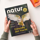 Magazintitel „natur – Das Magazin für eine Welt im Wandel“, Ausgabe 6/2025, in weißen Großbuchstaben auf dunklem Hintergrund, zeigt eine fliegende Schleiereule mit ausgebreiteten Flügeln. Darunter steht in gelber Schrift „Freunde der Nacht – Wie sich Eulen in der Welt behaupten“. Linke Spalte mit Themen: „Burundi“, „Zertifiziertes Palmöl“ und „Vogelkäfige“. Die Zeitschrift wird von zwei Händen über hellem Tisch mit orangefarbener Schale gehalten.