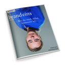 Schräg fotografierte, auf dem Kopf liegende Zeitschrift aus Papier mit blau-grauem Cover und weißem Rand; darauf das Porträt einer blonden Frau in blauem Oberteil vor grauem Hintergrund. Sichtbare Texte: „brand eins“, „Das geht!“, „Wie du mich siehst, bestimme ich.“, „brands.de“, „28. Jahrgang“, „Heft 08“, „August 2026“ und „Schwerpunkt Schönheit“.