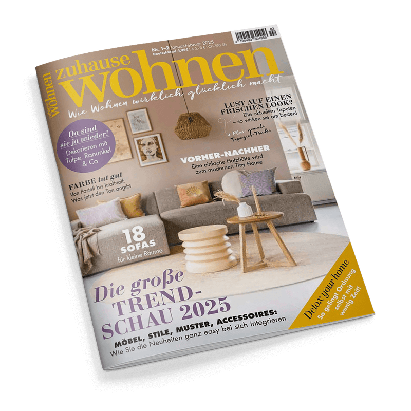 Titelbild der Zeitschrift „zuhause wohnen“, Ausgabe Nr. 1–2 Januar/Februar 2025, mit Wohnzimmermotiv: graues Sofa mit bunten Kissen, runder Couchtisch aus Holz, beige Teppich und Wanddekoration vor pastellfarbener Wand. Schlagzeilen u. a.: „18 Sofas für kleine Räume“, „Die große Trendschau 2025“, „Dekorieren mit Tulpe, Ranunkel & Co“, „Farbe tut gut“, „Vorher-Nachher – eine einfache Holzhütte wird zum Tiny House“, „Lust auf einen frischen Look?“.