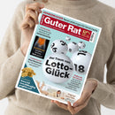 Person in beigem Strickpullover hält das Magazin „Guter Rat“ mit rotem Titelbalken und der Aufschrift „80 Jahre“. Hauptthema in der Mitte: große weiße Lotto-Kugeln mit schwarzen Zahlen und der Text „Der Traum vom Lotto-Glück“. Weitere sichtbare Überschriften: „KRANKENKASSEN Neue Leistungen für Versicherte“, „Superstar im Bauch – So halten Sie Ihren Darm gesund“, „Neue Alleskönner Nur Staubsaugen war gestern“, „Kam ich vom Höhenflug profitieren?“ und „Zeigt her eure Füße…“.