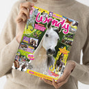Person in beigefarbenem Strickpullover hält eine bunt gestaltete Zeitschrift mit dem Titel „Wendy“. Das Cover zeigt ein großes graues Pferd vor grün-gelbem Hintergrund, umgeben von kleineren Pferdefotos und pinken, gelben sowie weißen Textelementen wie „5 süße Poster“, „Wunderschöne Schecken“, „Die Dressur-Stars“, „Comic Ein echter Barendiener“ und „Fotostory Karlshof auf Gut Spiegelberg“.