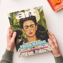 Titelblatt des Kunstmagazins „art“, Ausgabe Juli 2026, mit einem Porträt von Frida Kahlo vor grünem Blätterhintergrund, flankiert von einem schwarzen Affen und einer schwarzen Katze. Sichtbare Schriftzüge: „Jahrhundert-Schau in London“, „FRIDA KAHLO“, „Jenseits von Leben, Look und Leiden: Die Entdeckung einer Künstlerin“, „Die Poetik des Raums: Vilhelm Hammershøi in Zürich“, „Verrückte Genies? Ein Neurowissenschaftler über Kreativität“. Zwei Hände halten das Magazin über hellem Tisch.