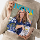 Hände einer Person im beigefarbenen Strickpullover halten schräg eine DONNA-Zeitschrift. Auf dem Cover ist eine lächelnde Frau mit langen braunen Haaren und blauem Jeanshemd abgebildet; lesbare Texte sind „Lesen, lachen, abtauchen“, „Neue Mode und die steht mir!“, „Der DONNA Stil-Guide für erwachsene Frauen“, „Zurück zur Jugendliebe?“, „Andalusien – dem Orient ganz nah“ und „Meine Zeit ist jetzt“.