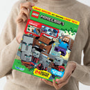 Person in beigem Strickpullover hält ein rechteckiges Magazin mit der Aufschrift „LEGO Minecraft Comic Special mit Original LEGO Set!“. Das farbige Cover zeigt Comicfiguren im kantigen Minecraft-Stil, darunter eine Figur mit Spitzhacke und mehrere graue Charaktere. Weitere sichtbare Texte: „Zwei Super Comics! Aufrüsten!“, „Meister und Lehrling“, „24 Seiten Comic“, „Achtung, Action!“, Verlagslogo „Blue Ocean“.