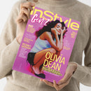 Eine Person in beigefarbenem Pullover hält ein Magazin „InStyle Gen Z“ mit pink-gelbem Titelblatt. Im Zentrum sitzt eine weiblich gelesene Person mit langem dunklem Haar, weißem Oberteil und schwarzer Shorts vor rosafarbenem Hintergrund. Aufschriften u. a.: „OLIVIA DEAN“, „7 Gründe, die sie zur neuen Icon ihrer Generation machen“, „Zahide did it better“, „We don’t gatekeep“ und „No more cringe“.