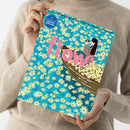 Beige gekleidete Person hält die Zeitschrift „flow“ mit großem rosa Titel in Brusthöhe; Cover zeigt eine Illustration eines Bootes mit zwei Personen, umgeben von weißen und gelben Gänseblümchen auf blauem Hintergrund, oben links blauer Kreis mit weißer Aufschrift „5 Lesezeichen & Bastelböglein“, obere Zeile mit schwarzem Text „Magazin für Persönlichkeitsentwicklung, Kreativität, Papeterie“.