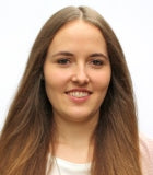 Porträt einer lächelnden jungen Frau mit langen braunen Haaren.