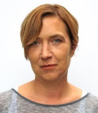 Porträt einer Frau mit kurzen rotblonden Haaren.