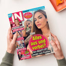 Zeitschrift „IN“ mit pink-weißer Titelschrift, von zwei Händen mit grauen Strickärmeln gehalten. Sichtbare Texte: „Praktisch: Feine Leckereien für unterwegs“, „Mittendrin! Die Promi-Partys der Woche“, „Alles aus und vorbei?“, „Bushido & Anna-Maria Ferchichi“ und „Ihre BEAUTY-OPS werden zum Problem“; auf dem Titel sind mehrere Personen abgebildet.