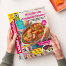 Aufgeschlagene Titelseite der Zeitschrift „Kochen & genießen“, von zwei Händen gehalten. Sichtbare Texte: „Was für ein Tomaten-Traum!“, „Schnell & köstlich: Airfryer-Rezepte“, „Der Pool ruft“ und „Erntefrisch & fruchtig: Sommerkuchen“; abgebildet sind ein Auflauf mit gefüllten Rouladen in Tomatensoße sowie ein Beerentörtchen, oben rechts ein orangefarbenes Tablett.