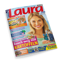 Schräg vor schwarzem Hintergrund abgebildetes, gedrucktes Magazin „Laura“ mit hellblauem Cover und großem rotem Titel. Darauf: blonde weibliche Person, Rezeptbilder und die Texte „Immer fix & lecker“, „Kuchen mit Schwiips + Neue Pizza-Ideen“, „Bauch weg mit Kartoffeln“, „Günstig reisen“, „Warnsignale früh erkennen“, „Beauty“ sowie „Urlaubs-Glück“.