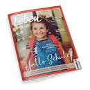 Schräg abgebildetes Cover des Elternmagazins „leben & erziehen“ mit rotem Rand und einem lächelnden Mädchen in gestreiftem Shirt, blauer Jeanslatzhose und rotem Rucksack. Sichtbare Texte: „Das Eltern-Magazin“, „Reise nach Marokko“, „Familien-Frieden“, „Selbst-Fürsorge“, „Aufs Bauchgefühl hören“ sowie Hinweise zur ersten Klasse, Linkshändigkeit, Vorschule und Brotbox.