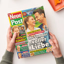 Schräg von oben fotografierte, glänzende Zeitschrift „Neue Post“, die von zwei Händen mit graugrünen Strickärmeln über einer weißen Fläche gehalten wird. Auf dem Cover sind eine Frau und ein Mann vor einer Landschaft sowie kleinere Porträtfotos abgebildet; lesbare Texte sind „Auf dem Gipfel des Glücks! Beatrice & Florian“, „Ihr Sommer voller Liebe“, „Zurück zur Familie!“, „Operation! Angst um sein Augenlicht“, „Liebes-Schock“ und „Großes Rezepte-Extra!“.