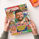 Schräg fotografiertes, farbig bedrucktes Papiermagazin „Neue Woche“, von zwei Händen gehalten, auf hellem Untergrund; oben rechts liegt ein orangefarbenes Kunststofftablett. Das Cover zeigt mehrere Frauen und Männer sowie die Texte „Heimliche Hochzeit!“, „PLEITE-ALARM!“, „Neue Liebe! Zerbrach wegen dieser Frau seine Ehe?“, „Thomas Müller“, „Victoria Swarowski“ und „Das große Rätsel-Magazin“.