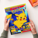 Pokémon-Magazin mit blau-gelbem Cover, großem gelbem Pikachu, Konfetti und Abbildungen von Pokémon-Karten und Figuren; das Heft wird von zwei Händen gehalten. Sichtbare Texte: „3D-Anhänger“, „Funpack“, „XL-Poster“, „Postkarten“, „Highlight-Ausgabe“, „Schnapp sie dir alle!“, „4 Postkarten mit Goldprägung!“, „Mit Mega-Gewinnspiel!“, „Panini“ und „www.pokemon.de“.