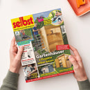 Diagonal gehaltenes Magazin „selbst ist der Mann – Das Do-it-yourself-Magazin“ mit gelbem Titelbild, Fotos von Gartenhaus, Geräteschuppen, Saunahaus und handwerklichen Arbeiten sowie Texten wie „Gartenhäuser – 2 Projekte selber bauen“, „Anti-Rost: Geländer aus Metall streichen“ und „Laub-Sau­bläser im Praxistest“. Zwei Hände halten das Heft über einer weißen Fläche; oben rechts liegt ein orangefarbenes Werkzeug auf einem Tablett.