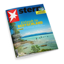 Schräg auf schwarzem Hintergrund liegendes „stern“-Magazin mit blauem Cover, rotem Feld und weißem Sternsymbol oben links. Das Titelbild zeigt einen See mit Bergen, Wolken, Bäumen, Felsen und mehreren badenden Personen; sichtbare Texte: „Urlaub in DEUTSCHLAND“, „30 Traumziele für Kurzentschlossene“, „FUSSBALL WM 2026“ sowie „Die große WM-Bilanz“.