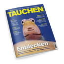 Schräg liegendes Magazin „TAUCHEN“ mit dunkelblauem Cover und Nahaufnahme eines gelblich-rosa Fisches mit großen schwarzen Augen und geöffnetem Maul vor blauem Wasser. Sichtbare Texte: „Wissen: Fotoschule – Sprechstunde – Apnoe-Tauchen“, „Geiseltalsee: Spektakulärer Unterwasserwald“, „Atemregler: Techniker-Kurs“, „Leserreise: Sonnenfinsternis mit Liveaboard“, „Entdecken“, „Sulawesi“, „Raja Ampat“ und „Bahamas“.