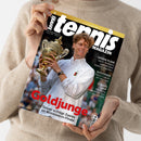 „tennis MAGAZIN“-Cover mit männlichem Tennisspieler im weißen Shirt, der einen goldfarbenen Pokal hält. Sichtbare Texte: „Goldjunge“, „Sinner schlägt Zverev im Wimbledon-Finale“, „GROSSE PLÄNE Saudi-Arabiens spektakuläre Stadion-Visionen“, „AUFSTEIGER Flavio Cobolli im Interview“, „STRUFFS LAUF Mit 36 ins Viertelfinale von Wimbledon“, „August 2026“ und „www.tennismagazin.de“; gehalten von einer Person im beigefarbenen Strickpullover.