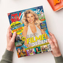 Schräg von oben gehaltene Ausgabe des Filmmagazins „TV Movie“ mit blauem Cover, einer blonden weiblichen Person im weißen Oberteil und Film- sowie Serienbildern. Sichtbare Texte: „FIRST IN ENTERTAINMENT“, „Mehr ERLEBEN“, „14 TAGE PREMIUM-PROGRAMM“, „SUPER-FILME!“, „TOP-SERIEN“, „GROSSER BUNDESLIGA-PLANER“ und „COLLECTOR’S EDITION“. Zwei Hände halten das Magazin; oben rechts liegt ein orangefarbenes Objekt.